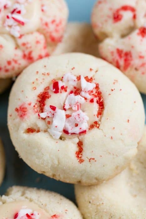 Classic Shortbread Thumbprint Cookies - an easy 5 ingredient dough to make 7 different Christmas cookies including raspberry, apricot and strawberry jam filling, Hershey's Kisses, Nutella and white chocolate with crushed peppermint candy canes! Best of all there's NO spreading or CHILLING required! Perfect for your holiday cookie platter!