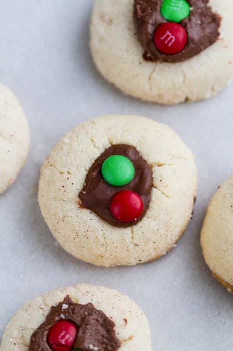 Classic Shortbread Thumbprint Cookies - an easy 5 ingredient dough to make 7 different Christmas cookies including raspberry, apricot and strawberry jam filling, Hershey's Kisses, Nutella and white chocolate with crushed peppermint candy canes! Best of all there's NO spreading or CHILLING required! Perfect for your holiday cookie platter!