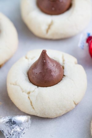 Classic Shortbread Thumbprint Cookies - an easy 5 ingredient dough to make 7 different Christmas cookies including raspberry, apricot and strawberry jam filling, Hershey's Kisses, Nutella and white chocolate with crushed peppermint candy canes! Best of all there's NO spreading or CHILLING required! Perfect for your holiday cookie platter!