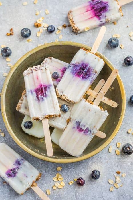 Blueberry Crumble Popsicles make the perfect easy frozen treat. Best of all, it's a healthy, vegan and refined sugar free breakfast or treat for summer. Made with coconut cream, blueberries, maple syrup and an granola oatmeal crumble. Simple and delicious.