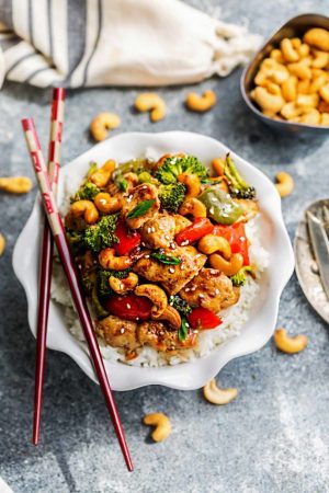 Cashew Chicken Sheet Pan has all the flavors of the popular Chinese restaurant takeout dish made on a sheet pan. Best of all, super easy to make with paleo friendly options. Plus a serving of tender crisp broccoli and red & green bell peppers for a healthier meal. Perfect for busy weeknights! Plus a step-by-step how to video! Weekly Sunday meal prep for the week and leftovers are great for lunch bowls & lunchboxes for work or school.