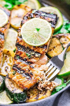 This Honey Lime Salmon is a light and tasty dish that is just perfect for summer and busy weeknights. Best of all, it can be made on the grill or in your oven. It's marinated with a delicious sweet and tangy honey and lime butter sauce and the salmon gets cooked to tender flaky perfection every time! Clean up is a breeze if you want to roast it in foil packs or cook it directly on the grill for those pretty grill marks!