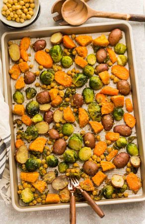 One Pan Roasted Harvest Vegetables - made with carrots, sweet potatoes, Brussels sprouts, baby potatoes and chickpeas. The perfect easy and delicious side dish for fall, Thanksgiving, Christmas or any busy weeknight meal! Best of all, so easy to customize and packed with crunchy panko crumbs and bursting with flavor from the Parmesan cheese, garlic and Italian seasoning.