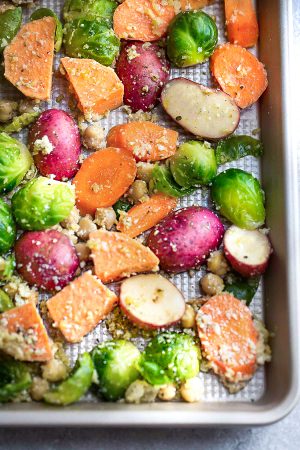 One Pan Roasted Harvest Vegetables - made with carrots, sweet potatoes, Brussels sprouts, baby potatoes and chickpeas. The perfect easy and delicious side dish for fall, Thanksgiving, Christmas or any busy weeknight meal! Best of all, so easy to customize and packed with crunchy panko crumbs and bursting with flavor from the Parmesan cheese, garlic and Italian seasoning.