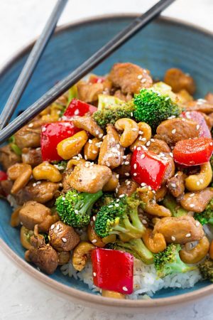 Healthy Cashew Chicken - an easy 20 minute guilt-free gluten free skinny version (plus paleo friendly options) of the popular classic Chinese takeout dish. Plus a serving of tender crisp broccoli and red bell peppers for a healthier meal. Best of all, this recipe comes together in less than 30 minutes in just one pan and perfect for busy weeknights!