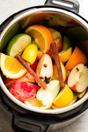 This Homemade Instant Pot Apple Cider Recipe is the perfect easy drink for fall and the holiday season. Best of all, made entirely from scratch in the pressure cooker with apples, orange, lemon, cranberries, cinnamon and cloves. Set and forget and makes your house smell amazing! Warm up with a mug by a cozy fireplace.