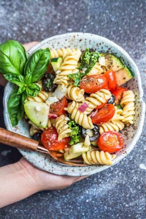 This Easy Italian Pasta is the perfect side dish for summer barbecues, potlucks, parties and cookouts. Best of all, you can customize the add-ins with what you have on hand. This recipe includes cherry tomatoes, zucchini, olives, feta cheese, onions, chopped kale and some fresh herbs like parsley and basil. A homemade Italian dressing makes this even more delicious!