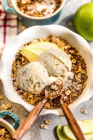 This recipe for Apple Crisp is the perfect easy fall treat. Best of all, these delicious mini crisps take no time at all to prepare and are gluten free, butter free and refined sugar free. Made with fresh apples, and the crispiest oat crumble topping. Serve it bubbling hot with some creamy vanilla frozen yogurt or vanilla ice cream for the ultimate autumn dessert. Make them in a regular pan or the mini size makes them great for potlucks, parties and baby showers!