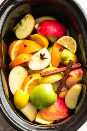 This Homemade Crock Pot (Slow Cooker) Apple Cider Recipe is the perfect easy drink for fall and the holiday season. Best of all, made entirely from scratch in the crock-pot with apples, orange, lemon, cranberries, cinnamon and cloves. Set and forget and makes your house smell amazing! Warm up with a mug by a cozy fireplace.