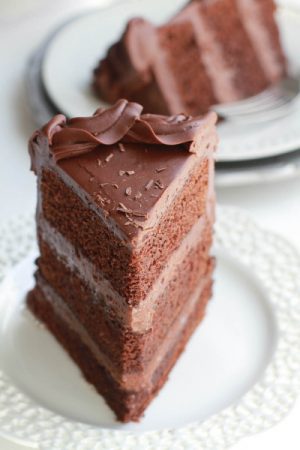 Ultimate Triple Chocolate Layer Cake - The best triple layer chocolate cake with the easiest milk chocolate frosting covered with mini chocolate chips.